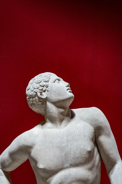 希腊男性雕像仰望红色背景